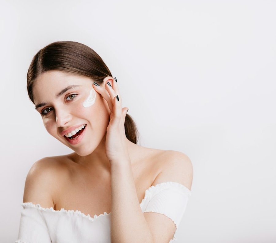 Người mẫu mỉm cười chạm nhẹ lên gương mặt